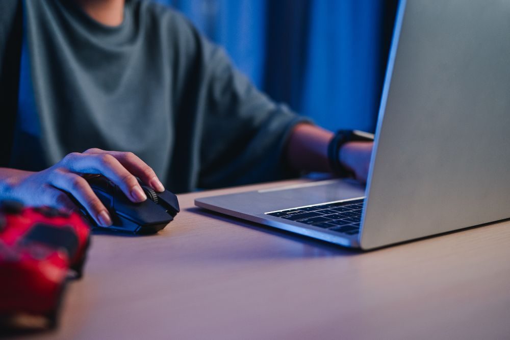 Notebooks Asus y MSI gamer enfrentadas en escritorio con luz LED